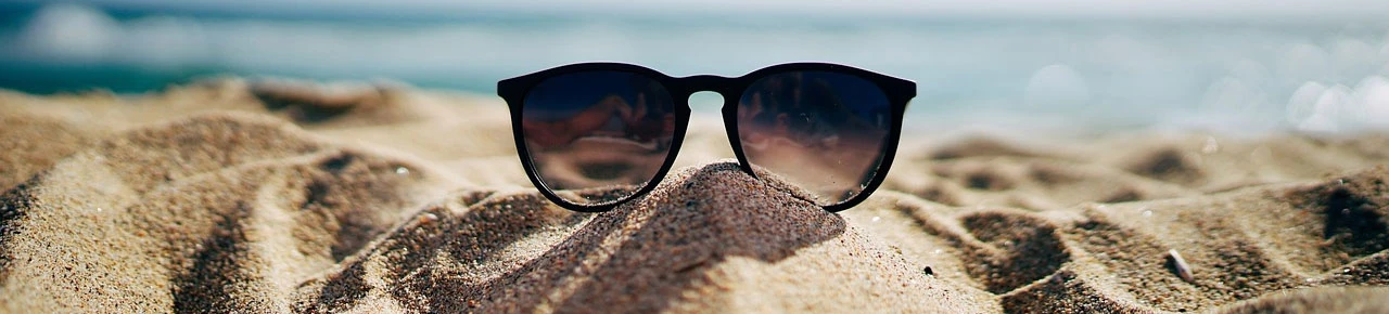 Sonnenbrille am Meer abgelegt zur erfrischenden Pflege nach dem Sonnenbad